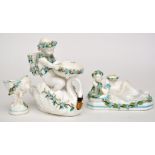 Two bone china salts, with turquoise enamel highlighting, one in the form of a putto on a swan,