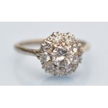 A diamond cluster ring, the central brilliant cut diamond estimated to weight approximately 0.