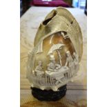 An Italian conch-shell lamp, cameo-carved with street scene,