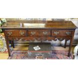 A George III cross banded oak low dresser having three frieze drawers, over a fret cut apron,