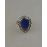 A pear-shaped black opal cabochon and diamond cluster ring, white metal set stamped 18ct Condition