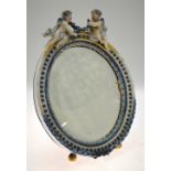 A Continental porcelain oval table  mirror surrounded by two cherubs, bevelled plate,