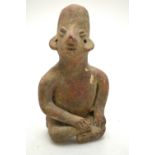 A central American terracotta figure of a man, sitting cross-legged, 15 cm high (by repute,