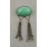 An Arts & Crafts green stone cabochon brooch having two suspended tassels with river pearl