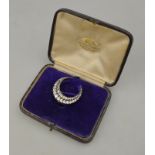 An Edwardian diamond set two-row crescent brooch set with old and rose cut diamonds, fitting