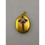 An oval bloomed gold locket having banded agate and pearl cross at front, monogram back,