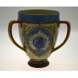 A Royal Doulton loving cup decorated with a flower head motif within a heart border, 18.5 cm high