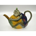 A Minton majolica teapot and cover modelled as a monkey clutching a large melon, his tail forming