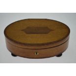 A 19th century oval maple and rosewood crossbanded trinket box with compartmented interior enclosed