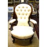 A Victorian carved walnut button-backed elbow chair with concave overstuffed seat