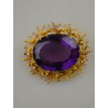 An oval brooch containing a large amethyst of good colour in yellow gold cannetille work setting, 2.