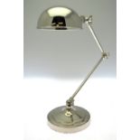 A nickel-plated adjustable desk lamp with domed shade