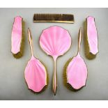 A pink basse-taille enamel and silver gilt six-piece brush set including two pairs of brushes,