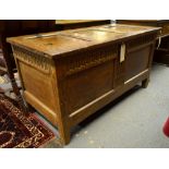 A 17th/18th century oak coffer, the hinged three panel top over an arcaded frieze and twin panels,