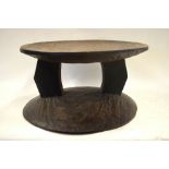 An African hardwood circular low table with dished top,
