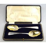 A cased pair of silver serving spoons of George III origin with later floral-chased gilt bowls and