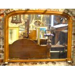 A Victorian satinwood framed arched overmantel raised on ceramic feet,