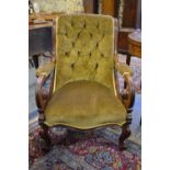 A Victorian mahogany button-back upholstered armchair raised on  turned front supports