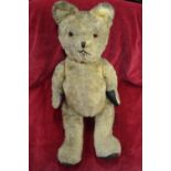 A large vintage mohair teddy bear with glass eyes and stiched nose and mouth,