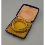 A 9ct yellow gold half engraved bangle approx 12g (bruised) in fitted box