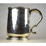 A George II silver plain pint mug of lightly tapering form with scroll handle and moulded foot-rim,