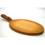 A Thompson of Kilburn 'Mouseman' oval cheese board, the handle carved with the traditional mouse,