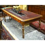 A Victorian mahogany library table having an inset leather top over three frieze drawers raised on