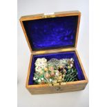 A wooden jewel box containing a quantity of vintage jewellery including rings, bracelets,