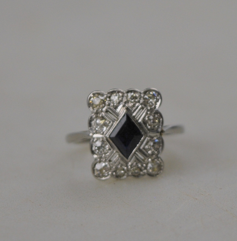 An Art Deco plaque-style cluster ring set in the centre with a diamond-shaped sapphire with old cut