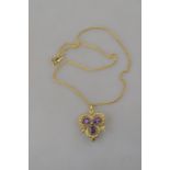 An Edwardian style amethyst and seed pearl trefoil pendant brooch with amethyst drop,