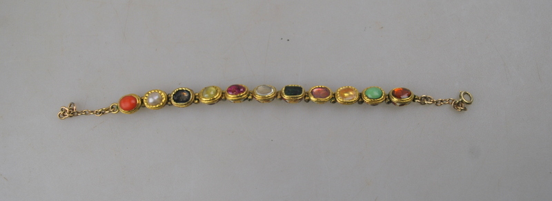 An Indian gold bracelet set with coral, pearl, chrysoberyl cat's eye, ruby, diamond, tourmaline,
