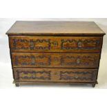 An 18th century Italian provincial oak/walnut commode chest of three long drawers each with carved