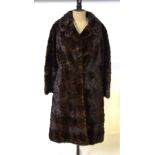 A dark brown mink fur coat with brown satin lining,