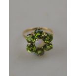 A peridot cluster ring with a cabochon opal in centre, 9ct yellow gold claw setting,