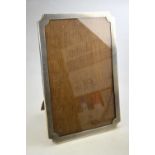 A silver easel photograph frame with engine-turned decoration and oak back, Saunders & Mackenzie,