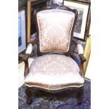 An antique French walnut framed upholstered salon armchair with overstuffed serpentine seat