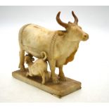 An Indian soapstone model of a water buffalo and calf raised on a rectangular base,