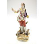 A Meissen porcelain figure of a male singer holding sheet music in his right hand,