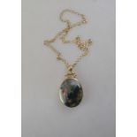 A moss agate and jasper oval pendant in 9ct collet setting on 9ct chain