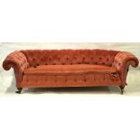 A Victorian button backed Chesterfield sofa by Howard & Sons, London, the back castors stamped,