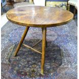 An elm cricket table, the circular top raised on tripod legs united by a 'T' stretcher, 85.