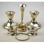 A pair of loaded silver low candlesticks, Birmingham 1915, to/w two napkin rings,