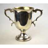 A George III silver loving cup with twin scroll handle and campana-shaped bowl, on waisted stem,