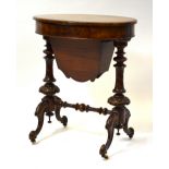 A Victorian rosewood work table, the oval hinged top enclosing a bright interior,