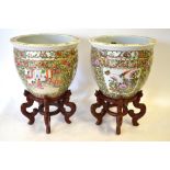 A pair of Chinese Canton famille rose jardiniere decorated with alternating panels of figures on a