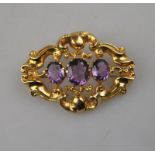 A 9ct Victorian style scroll brooch set with three amethysts