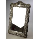 A late Victorian easel mirror with ornately embossed and chased silver front, Henry Matthews,