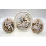 Three circular bisque plaques moulded with scenes of courting couples in rural settings, 25.