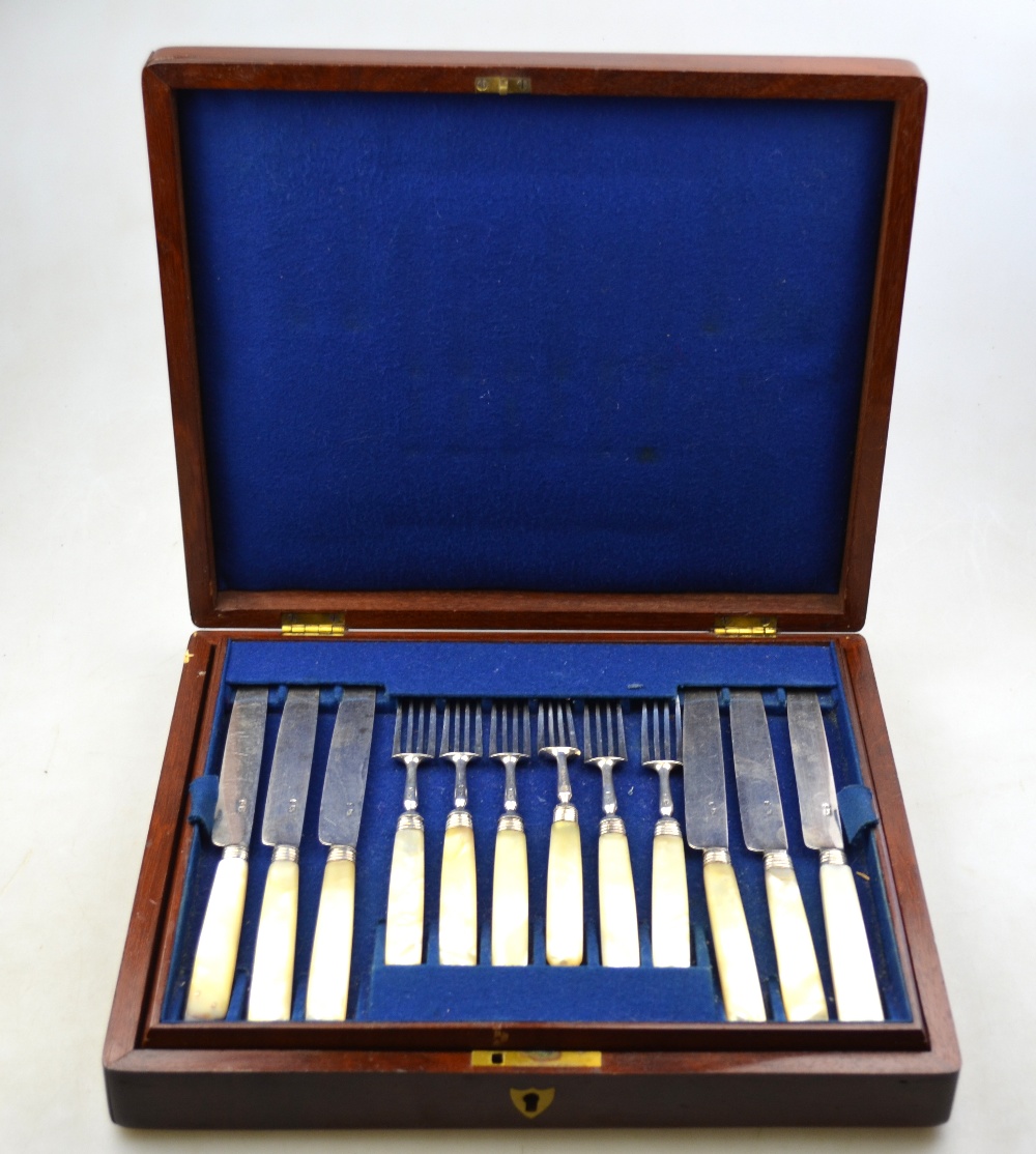 A mahogany cased set of twelve Georgian silver dessert knives and forks with reeded ferrules and