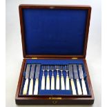 A mahogany cased set of twelve Georgian silver dessert knives and forks with reeded ferrules and